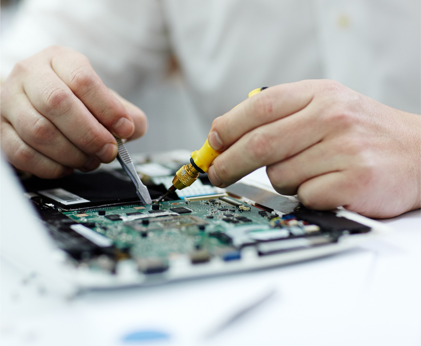 se aprecia manos empleando herramientas electrónica sobre una placa de un aparato electrónico